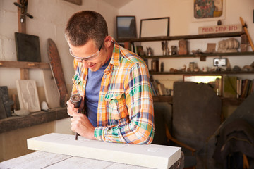 Stone Mason At Work On Carving In Studio