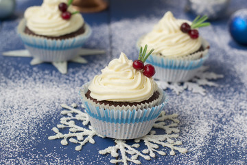 Fototapeta na wymiar Chocolate cupcake with cream cheese in Christmas decorations