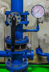 Water pressure gauge meter installed on a blue pipe