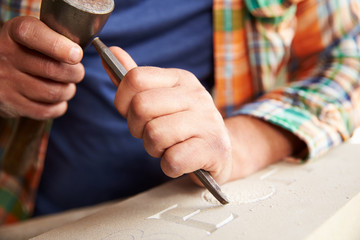 Close Up Of Stone Mason At Work On Carving In Studio - obrazy, fototapety, plakaty