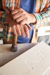 Close Up Of Stone Mason At Work On Carving In Studio