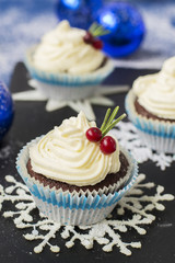 Chocolate cupcake with cream cheese in Christmas decorations
