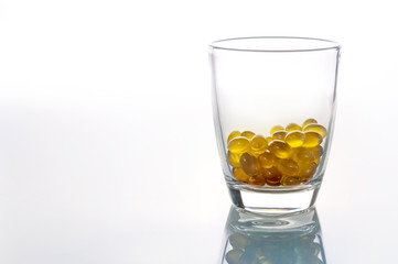 oil capsules in glass on white background  with copy space..jpg