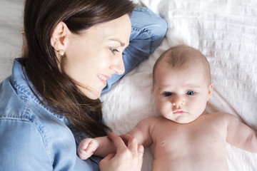 baby and mother in white bed taking good time