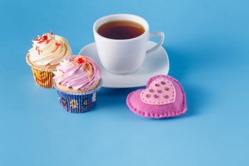 Obraz na płótnie Canvas Heart symbol with cupcakes and tea