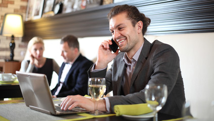 Business man with the laptop sits at a table in cafe