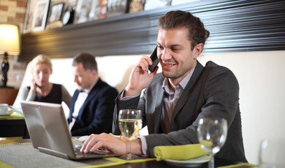 Business man with the laptop sits at a table in cafe
