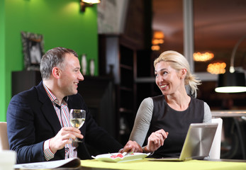 Flirting couple in cafe using digital tablet 