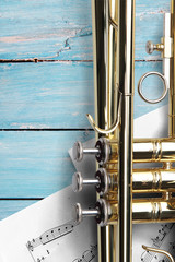 Trumpet with sheet music on blue wooden boards