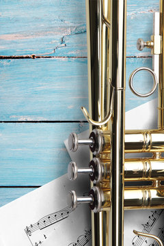 Trumpet with sheet music on blue wooden boards
