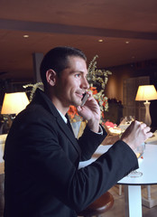 handsome man drinking cocktail in a stylish bar