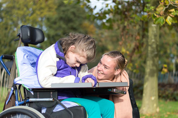 Fototapeta na wymiar Disabled girl relaxing outside / disabled girl relaxing outside together with a care assistant