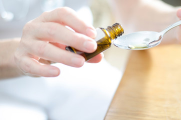 Obraz premium Tropfen werden auf einen Löffel gegeben