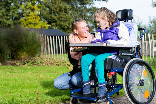 Disabled girl relaxing outside / disabled girl relaxing outside together with a care assistant