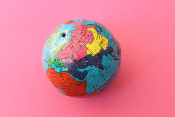 Close up of world globe - top view - travel destination and love different cultures concept - place for text - on pink background
