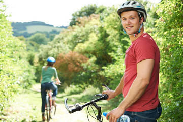Young Couple Cycling Along Country Track