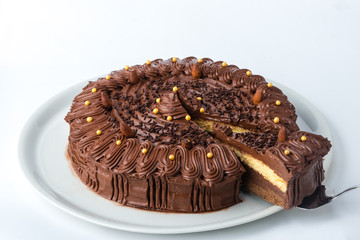 Homemade cake with black chocolate served on a white plate. Studio shot on white background.