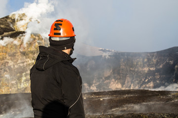 geologist looks at the craters of the erupting volcano Etna