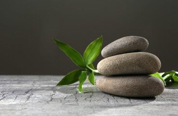 Black spa stones and green flowers, on dark grey background