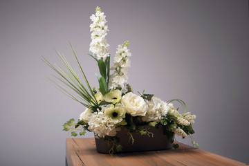 Artificial flowers bouquet in vase on the table