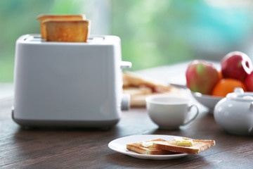 Served table for breakfast with toast, coffee and fruit, on blurred background