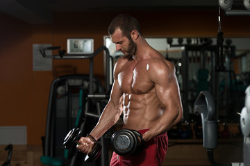 Fototapeta na wymiar Healthy Young Man Doing Exercise For Biceps