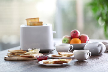 Served table for breakfast with toast, coffee and fruit, on blurred background
