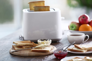 Served table for breakfast with toast, coffee and fruit, on blurred background