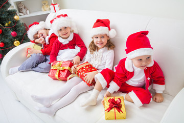 Group of four children in Christmas hat with presents