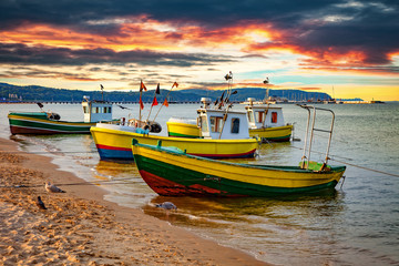 Picturesque landscape of a sunset with a boats on beach in Sopot, Poland. - obrazy, fototapety, plakaty