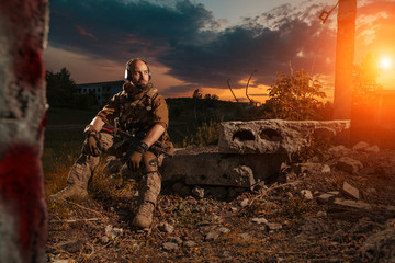 American soldier with the M4 rifle is having a rest. Sunset on t
