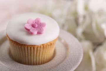Tasty cupcake on stand, on light background
