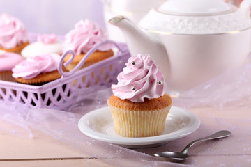 Tasty cupcake on saucer, on light background