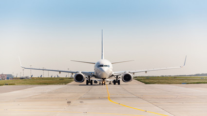 Obraz premium Biały samolot odrzutowy na pasie startowym