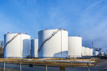 white tanks in tank farm with blue sky