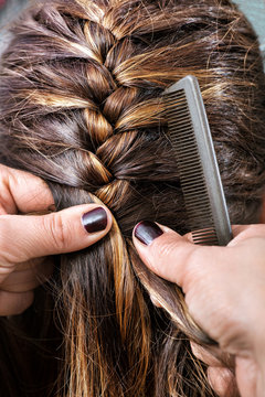 Hairdresser braiding a clients hair