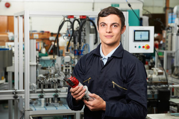 Apprentice Engineer Checking Component In Factory - obrazy, fototapety, plakaty