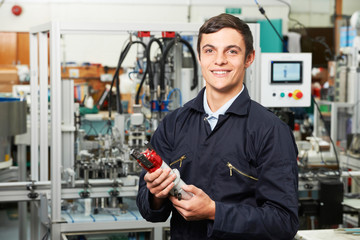 Apprentice Engineer Checking Component In Factory