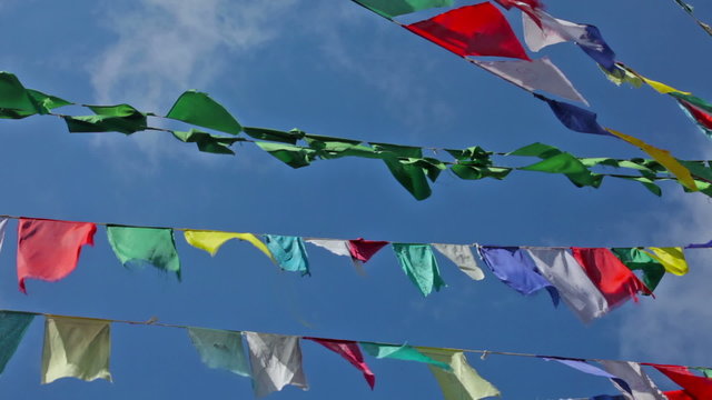 Buddhist prayer flags lungta (wind horses) against sky on kora around Tsuglagkhang complex. McLeod Ganj, Himachal Pradesh, India