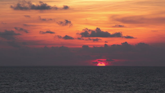 Sun setting into ocean and hiding behind horizon.  Goa, India