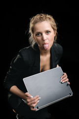 woman in a suit with the laptop shows tongue