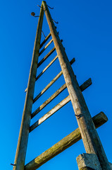 old triangel electricity wooden pole with blue sky
