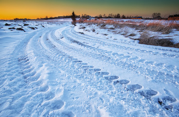 Fototapeta na wymiar traces of the car wheels on a snowy road