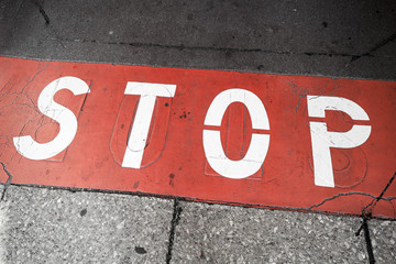 Road marking with stop label over red line