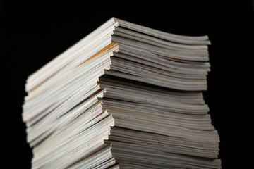 Stack of magazine isolated on black background with shallow depth of field