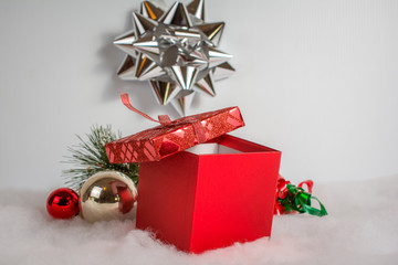 Red gift box with silver bow in background