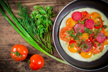 Fried eggs with greens, sausage and tomato