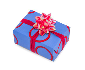 Gift box wrapped in blue paper with red rings and pink sequin bow. Main colors are blue, red and pink. Holidays and events theme.