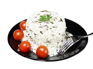Rice with cherry tomatoes and greens on a black plate
