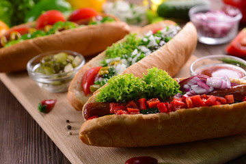 Hot dogs and vegetables on wooden cutting board